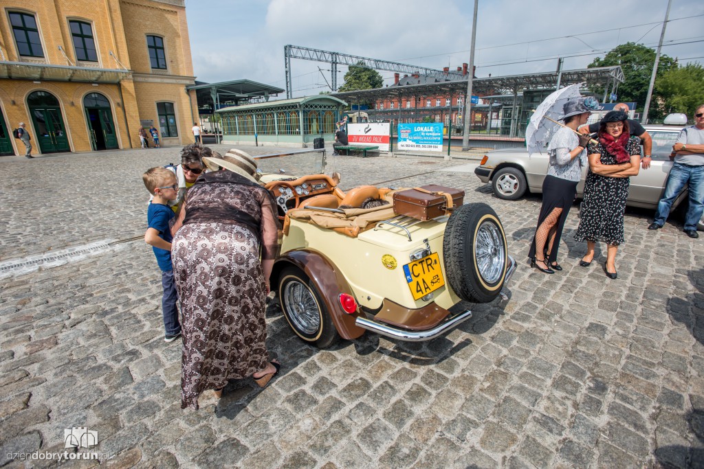 Parowozy i automobile na dworcu