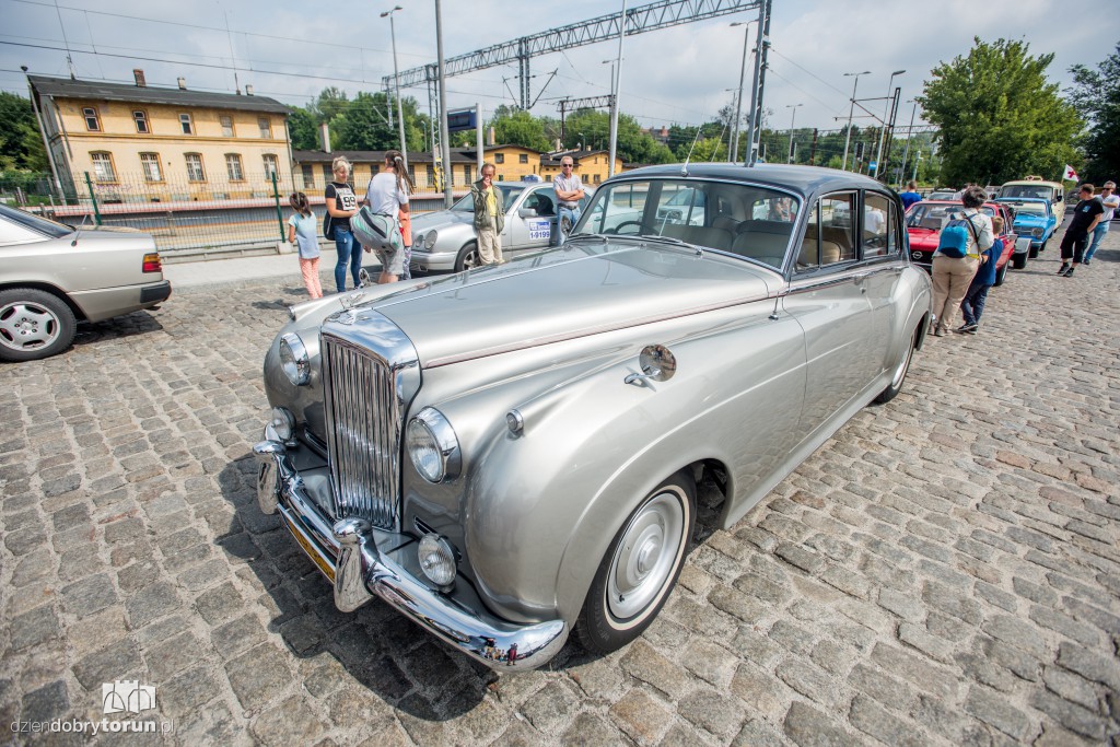 Parowozy i automobile na dworcu