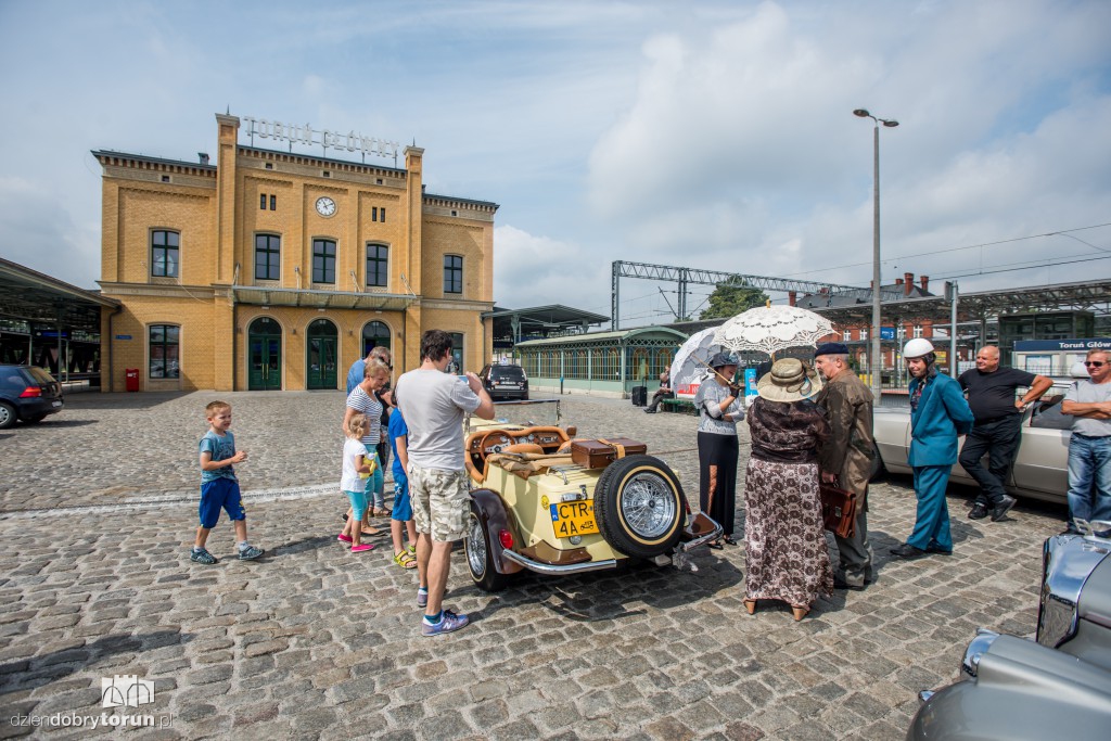 Parowozy i automobile na dworcu