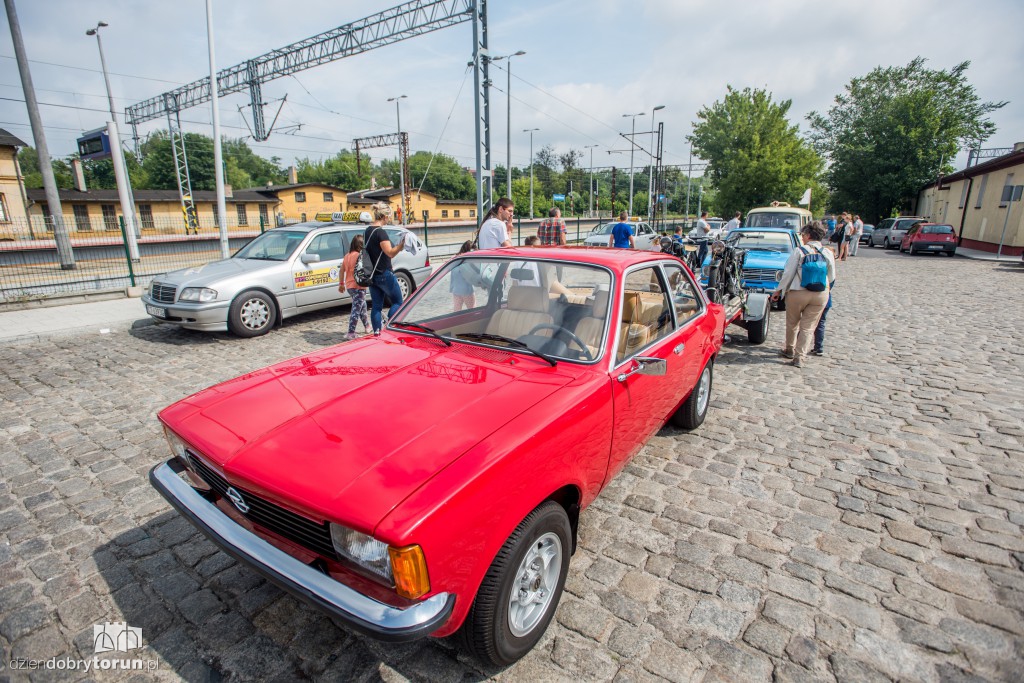 Parowozy i automobile na dworcu