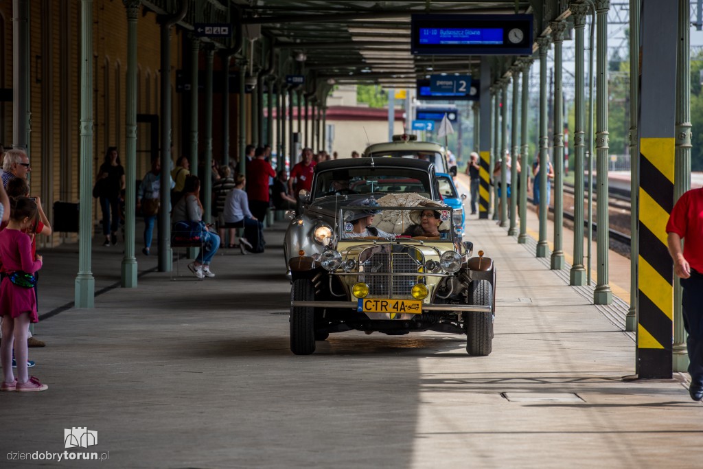 Parowozy i automobile na dworcu