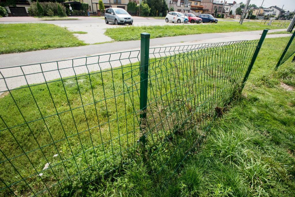 Plac zabaw z wysoką trawą i bez ogrodzenia