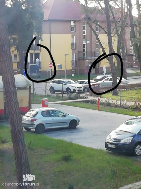 Mężczyźni w białych kaftanach w jednym z bloków