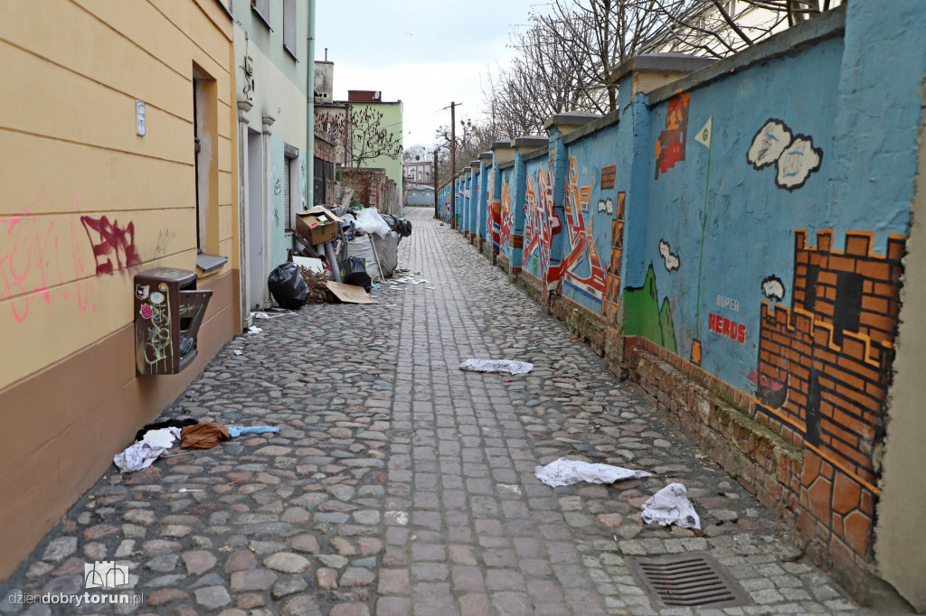 Śmieci i graffiti na małej ulicy na starówce