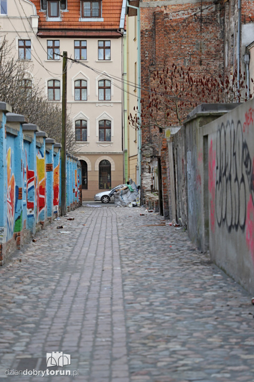 Śmieci i graffiti na małej ulicy na starówce