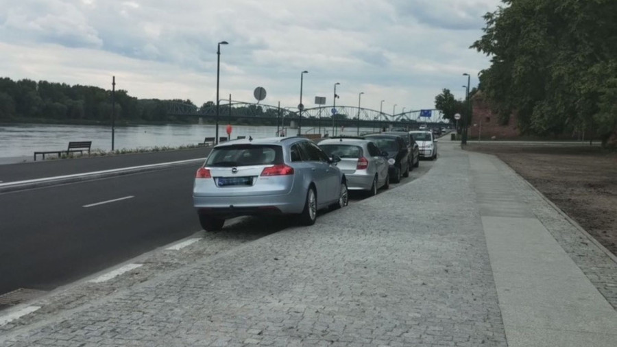 Samochody zaparkowane wzdłuż ulicy Bulwar Filadelfijski w Toruniu. Widać zatokę parkingową, drogę oraz rzekę Wisłę. Fot: MZD Toruń
